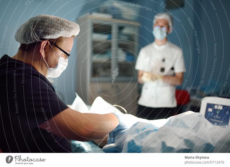 Professional vascular surgeon and assistant in the operating room of the clinic during vein surgery. Phlebectomy phlebectomy operation doctor endovascular