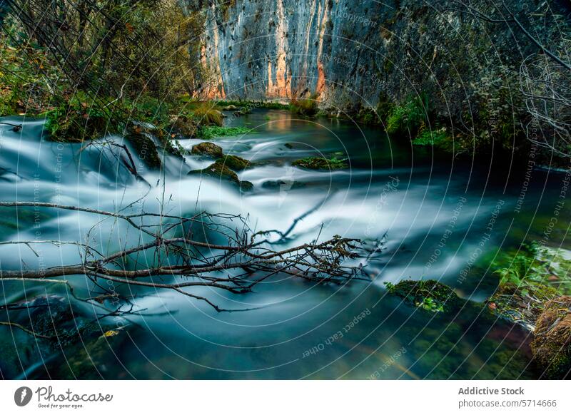Silky water flows through the Escabas River in Cuenca, framed by rocky cliffs and overhanging branches Water Flow Smooth Rocky Cliff Branch Overhanging Nature