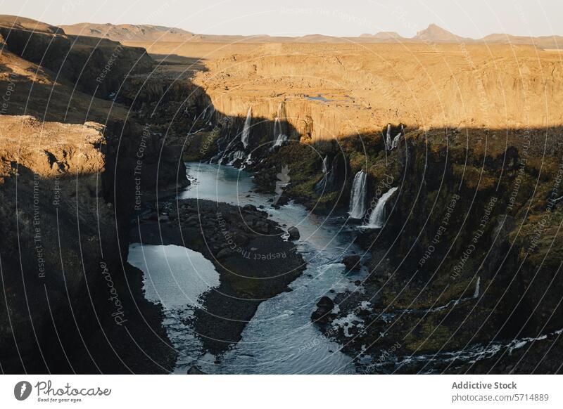 Scenic view of Iceland's Fjadrargljufur Canyon and waterfalls iceland fjadrargljufur canyon landscape natural beauty golden hour scenic view river cliff cascade