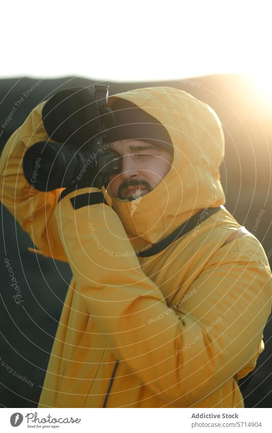 Generated image photographer camera man male sunrise morning focus lens portrait concentration hobby profession activity yellow hooded jacket cold weather