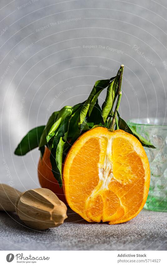 Fresh cut orange with leaves and wooden juicer fruit fresh leaf citrus healthy food vibrant green nutrition natural ripe raw diet vegetarian organic vitamin c