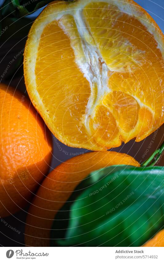 Fresh orange slice with whole oranges in the background juicy fresh fruit citrus leaf blue surface food vitamin health ripe segment pulp delicious natural