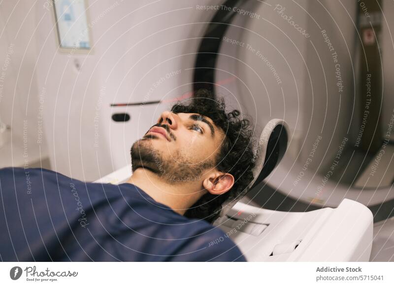Young man undergoing an MRI scan in a hospital mri medical imaging machine healthcare patient male young adult lying down technology diagnosis equipment room