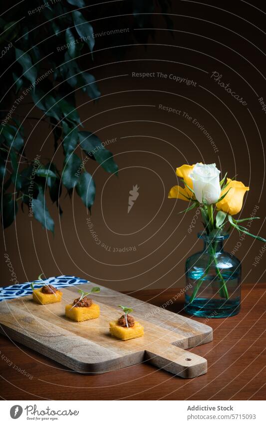 Elegant polenta canapé with tomato and onion stew wooden board rose vase yellow blue backdrop appetizer gourmet snack food presentation elegant yellow rose