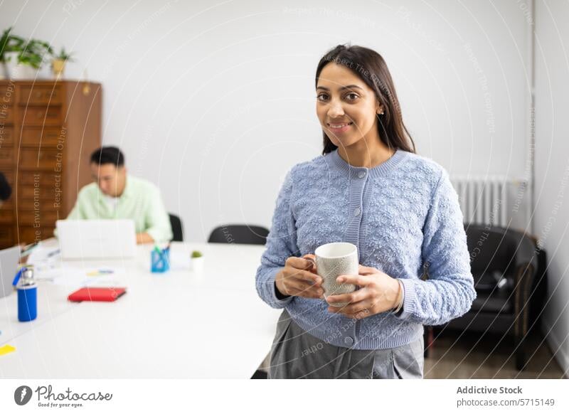 Smiling businesswoman with coffee cup in office colleague professional smiling cheerful corporate work environment desk laptop male background break beverage
