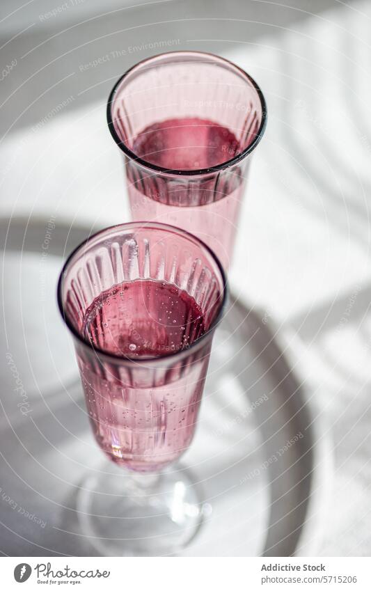 Elegant pink glasses on a sunny table setting. Generative AI image shadow light delicate white beverage container transparent elegance style modern color
