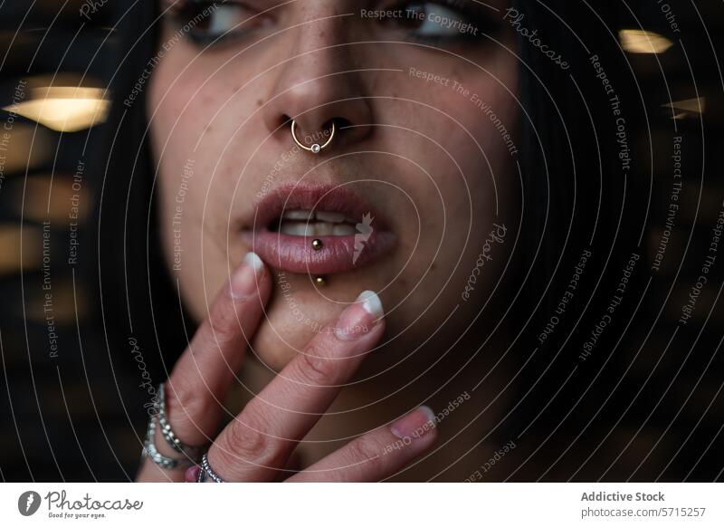 Close-up of a Pensive Woman with Piercings in Urban Madrid woman thought piercing nose ring lip ring close-up urban madrid four towers business area young