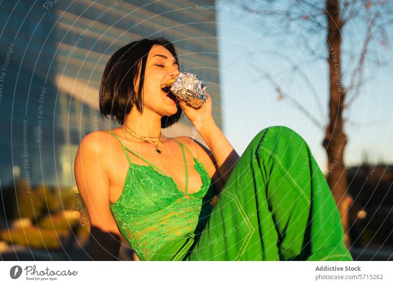 Young woman enjoying a snack in Madrid's 4 Towers district young eating madrid spain urban style cuatro torres modern backdrop fashion stylish outdoor city life
