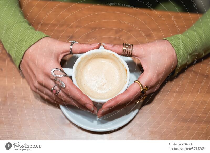 Cozy coffee moment with hands holding a cup warm comfort close-up relax beverage drink espresso cappuccino latte cafe morning break refreshment wooden table