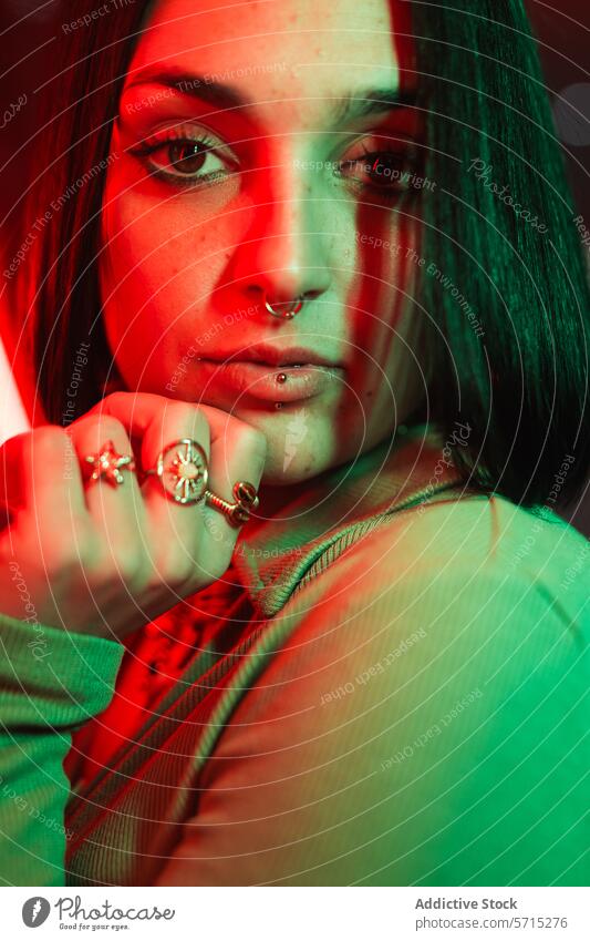 Urban style portrait with colorful lighting woman piercing close-up urban red green moody young fashion face jewelry rings expressive mysterious vibrant night