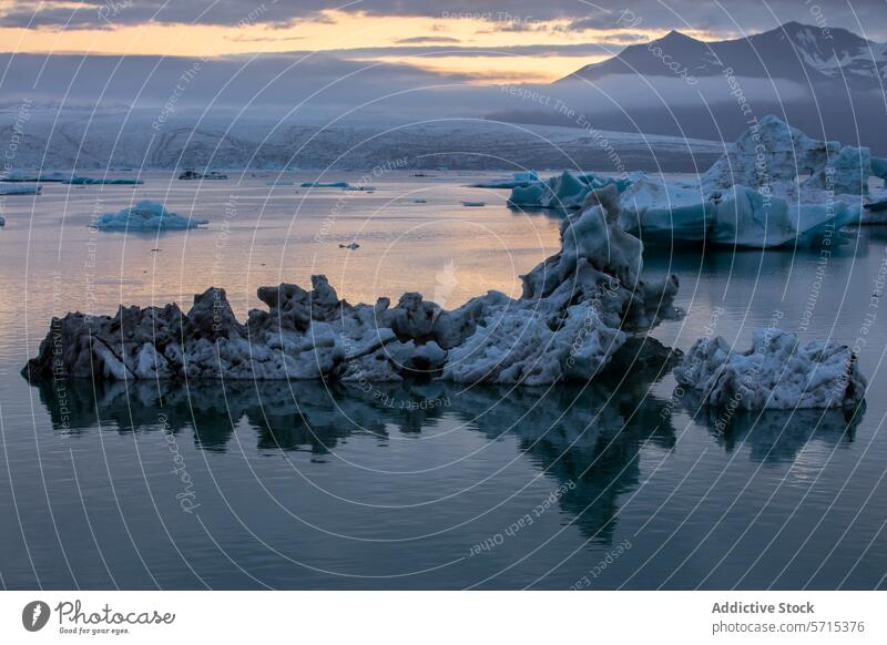 Serene glacier lagoon in Iceland at dusk iceland jÃ¶kulsÃ¡rlÃ³n serene tranquil iceberg reflection water surface mountain backdrop glow landscape nature cold