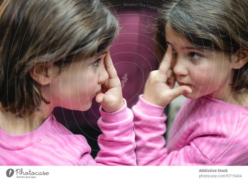 Girl Reflecting in a Mirror wearing Pink girl reflection mirror pink top child curiosity innocence contemplation thoughtful indoors person kid female youth
