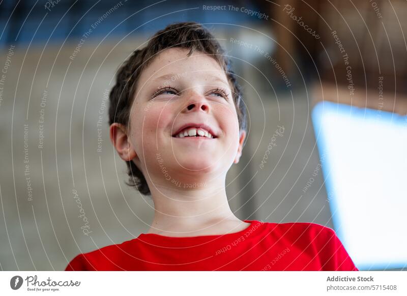 Joyful boy during a sport weekend event child joy happiness red shirt smiling cheerful exuberant kid youth emotion carefree fun activity sporty looking up