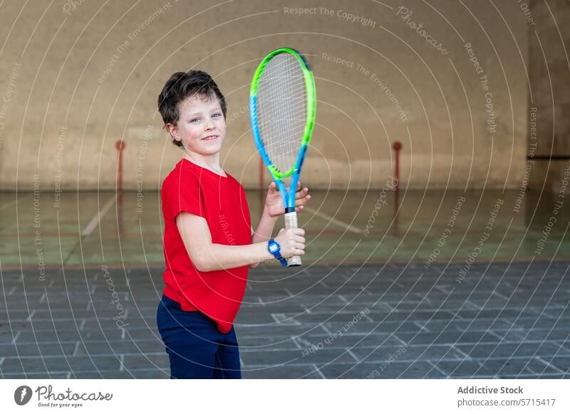 Youth tennis player ready for sport weekend boy racket court indoor youth active child sporty athlete young smile confident red shirt hobby leisure activity
