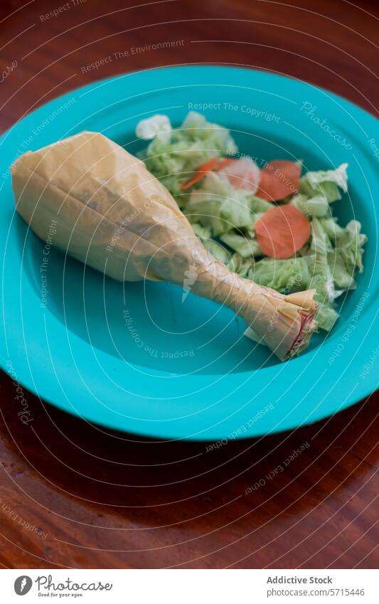 Conceptual plastic food on a child's plate concept fake chicken drumstick paper salad blue imitation eco pollution waste plastic bag environment message