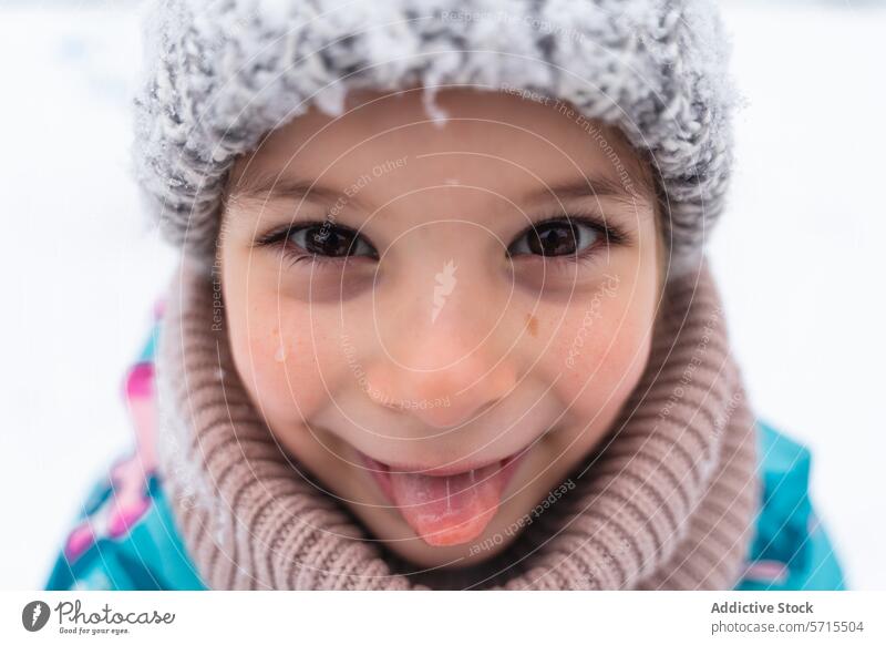 Close-up of a joyful child with a snowy hat smiling on a winter day Child smile close-up outdoor cold season happiness youth playful snowflake warm clothing