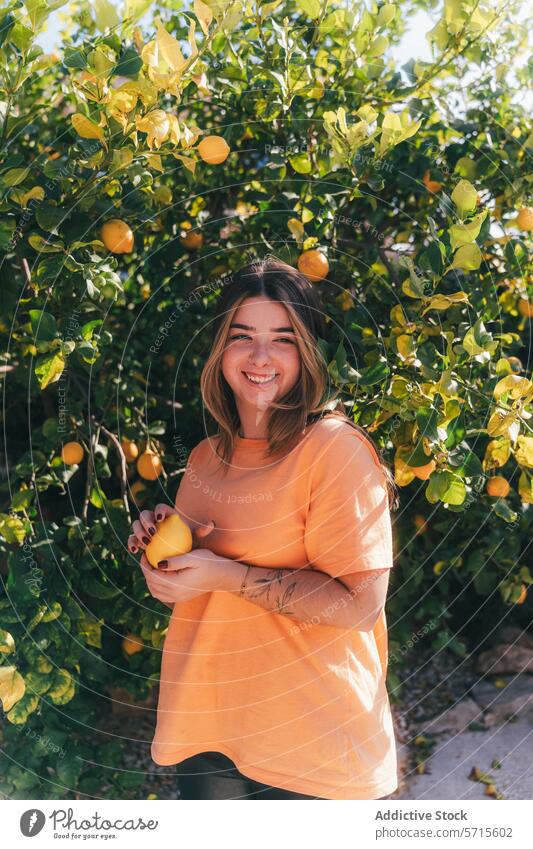 Smiling Young Woman Harvesting Lemons in Home Garden woman lemon tree garden harvesting citrus fruit picking smile cheerful young orange shirt lush nature