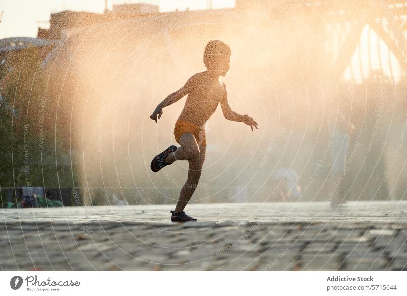 Captured in the warm glow of sunset, a joyful child dances in the water mist of an urban fountain, embodying the spirit of summer city playful warm light