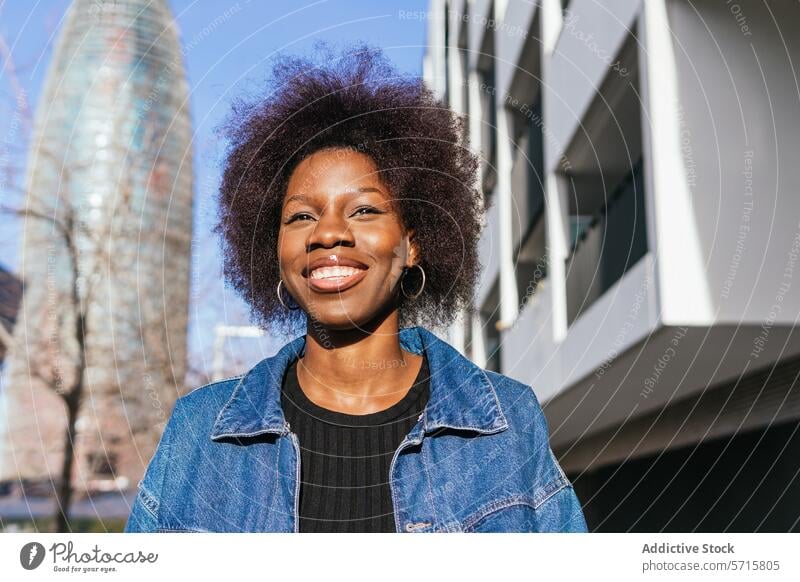 A radiant African American woman with a confident smile stands in an urban landscape, the city's architecture framing her natural beauty black ethnic cityscape