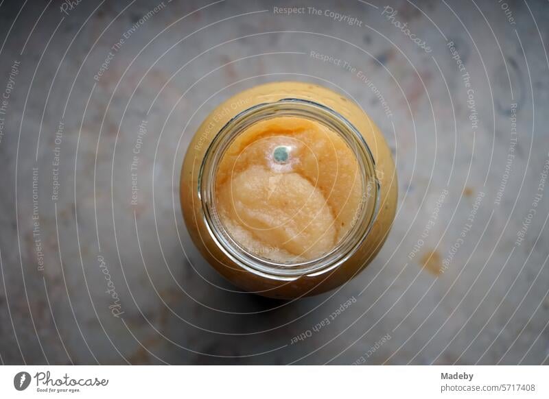 Boiled down applesauce in an open canning jar with mold or mildew on the windowsill in the pantry in Oerlinghausen near Bielefeld in the Teutoburg Forest in East Westphalia-Lippe