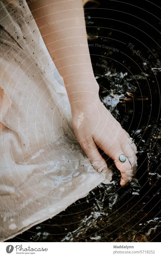 Woman running her hands through water, Hands with rings on them Rings woman Bride romantic Romance Water aesthetic details Adults Love River fabric wash Dress