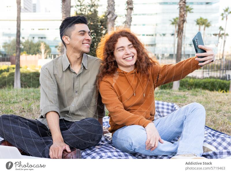 Smiling diverse students enjoying a picnic and taking a selfie smartphone happy woman latin redhead park youth diversity outdoors casual friendship technology