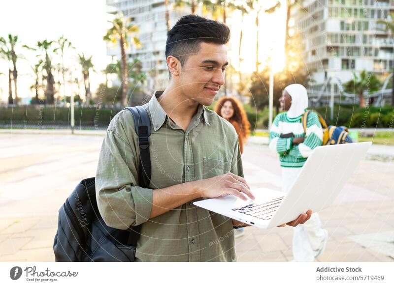 Students with Laptop Outdoors Enjoying Sunshine student laptop outdoor sunshine campus life diverse multicultural latin man african american woman palm trees