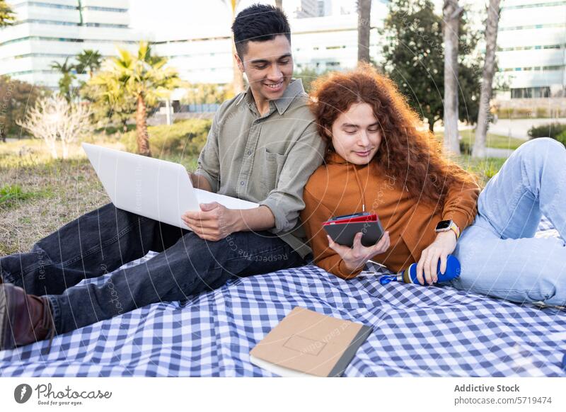 Students Studying and Relaxing at Outdoor Picnic picnic students studying outdoor laptop notebook smartphone man woman diversity multiethnic relaxed casual
