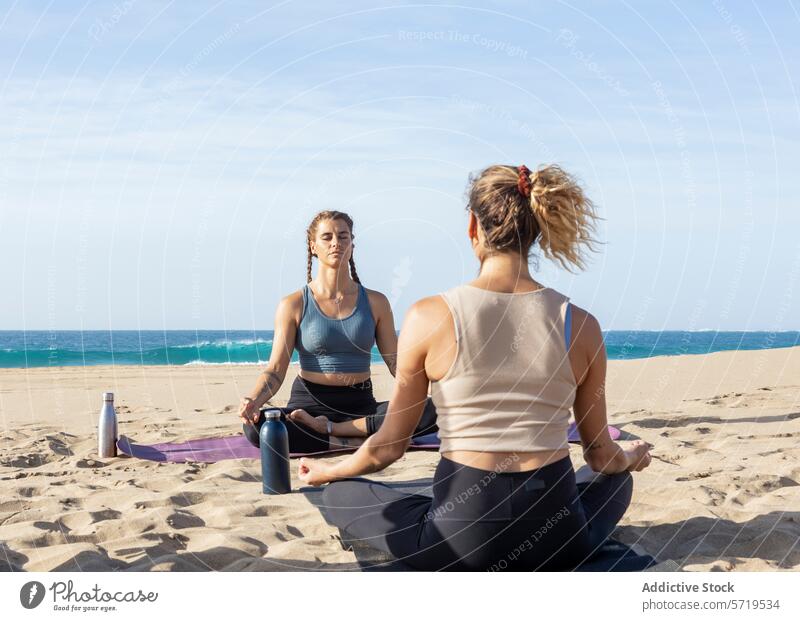 Serene beach yoga session at sunset practice individual sandy tranquil water bottle mat relaxation exercise healthy lifestyle woman peace calm zen mindfulness
