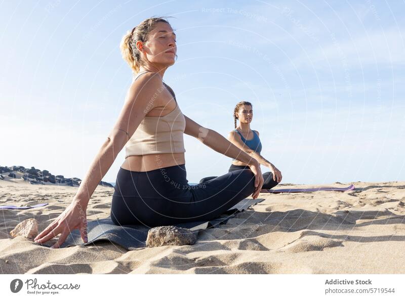 Beach Yoga Class at Sunset in Easy Pose yoga beach class sunset relaxation women sukhasana pose practice wellness mindfulness easy pose sand tranquility fitness