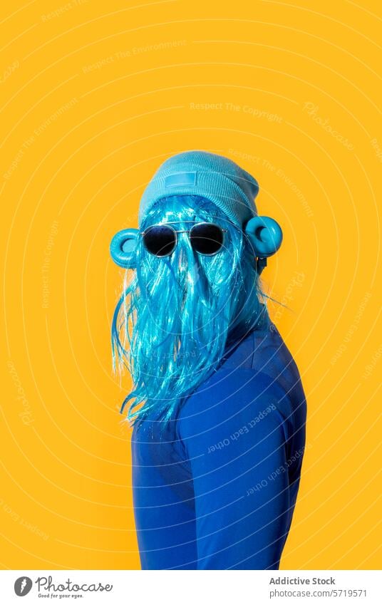 Eccentric blue wig and sunglasses on a yellow background person headphone colorful quirky bright vivid pop culture fashion eccentric costume disguise synthetic