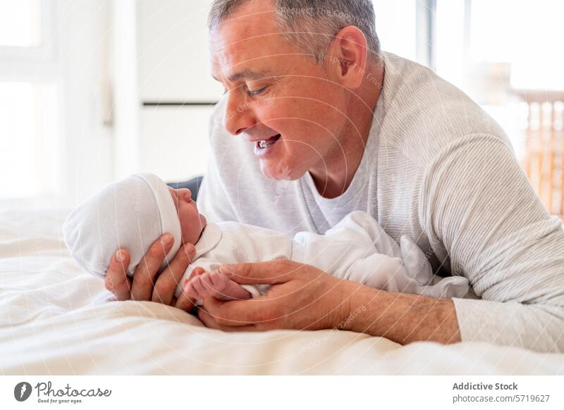 An endearing moment as a playful dad interacts with his attentive newborn baby, both enjoying a warm family connection interacting interaction father child