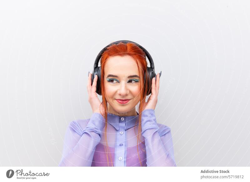 Smiling Businesswoman with Headphones Enjoying Music businesswoman headphones music listening smiling red hair professional white background adult pleasure