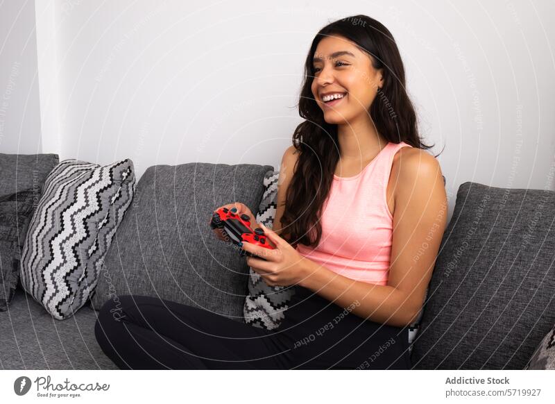 Smiling woman enjoying gaming on couch smiling game controller wireless relaxation entertainment leisure indoor living room casual technology video game happy