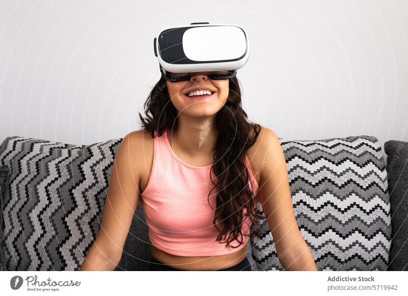 Smiling young woman experiencing virtual reality adult vr headset hispanic middle eastern female 20s smile amusement joy pink top sleeveless brown hair