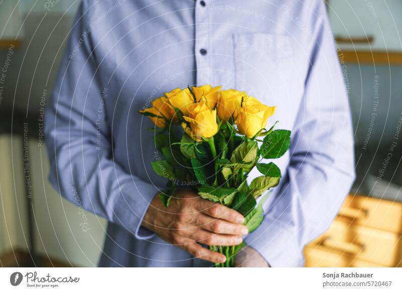 A man in a blue shirt holds a bouquet of yellow roses in his hands Man Bouquet Gift stop Birthday Valentine's Day Spring Love Mother's Day Flower Blossom