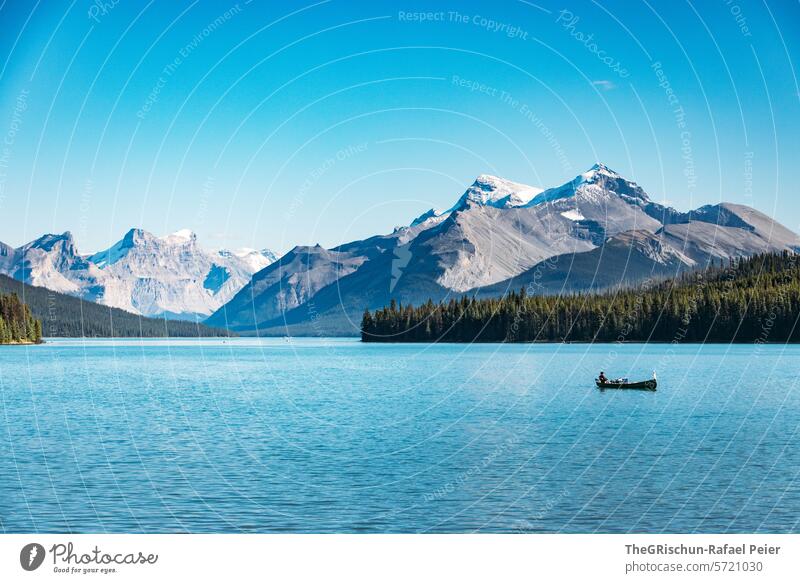 Boat is on a lake surrounded by mountains Lake Maligne boat Mountain Canada travel Boating trip Blue Turquoise touristic Tourism Exterior shot Colour photo