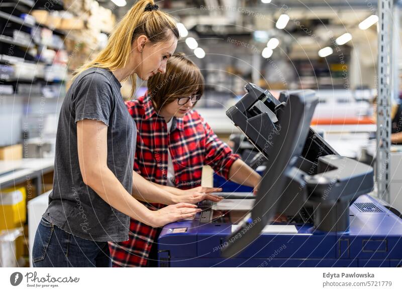 Professional female employees working in a printing house business factory industrial industry job logistics manufacture manufacturing occupation people product