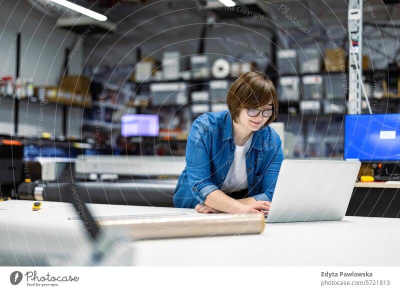 Woman using laptop at printing factory business employee female industrial industry job logistics manufacture manufacturing occupation people product production