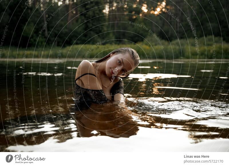 Water is the best friend of this gorgeous brunette girl. She’s in a river on a golden hour surrounded by the great green nature. Her dress is wet and she is playing with the camera flawlessly.