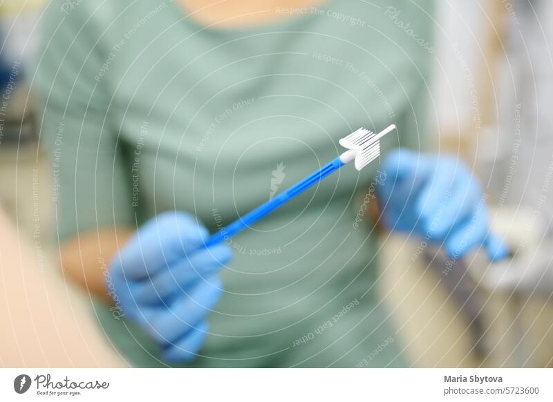 Gynecologist examines a patient takes a smear from a woman cervix. Close up view of doctor hands with gynecological cytobrush. Diagnosis of female viral and infection diseases