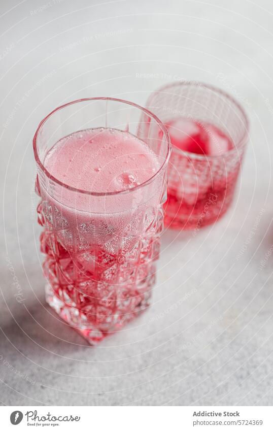Pink cherry vodka and tonic cocktail with ice glass cube drink beverage alcohol pink bubble effervescent refreshment textured mixology bar fizzy serve cold pour
