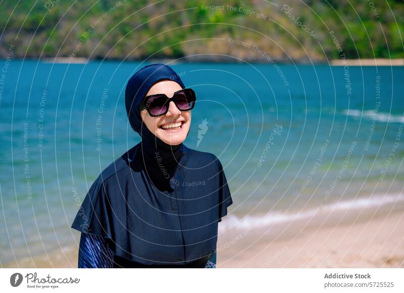 Smiling Woman in a Burkini Enjoying the Beach woman burkini beach smile sunglasses muslim swimwear modesty fashion summer sunny coast seaside happy enjoyment