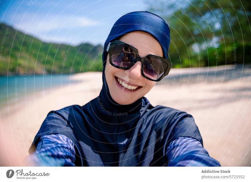 Smiling woman in burkini enjoying the beach smile selfie swimwear modest muslim sunny sand hills fashion enjoyment outdoors coastal summer vacation leisure