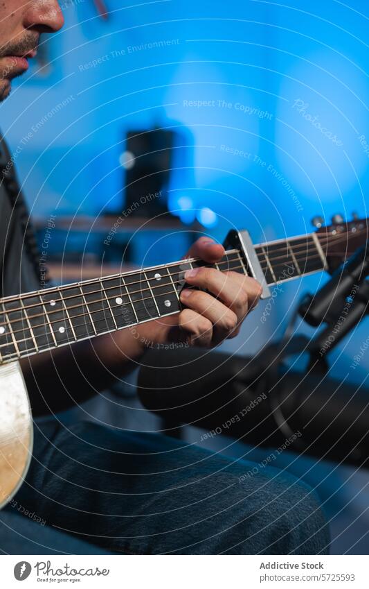 Anonymous male guitarist recording music in a sound studio session acoustic guitar playing hands close-up ambient lighting musician performance instrument