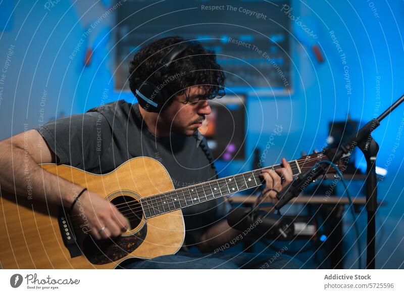 Musician recording acoustic guitar in studio musician session headphones microphone playing sound equipment technology focus man instrument audio production