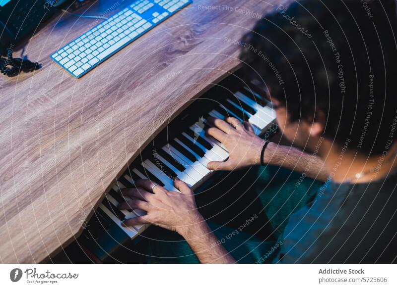 Musician playing keyboard during studio session musician sound studio recording equipment overhead view hands computer keyboard skill audio production artist