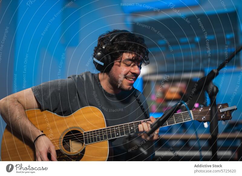Musician recording acoustic guitar track in studio musician sound session male headphones playing song equipment mixing background artist performance production