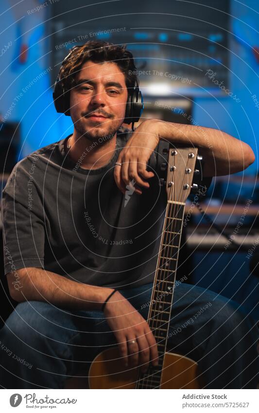 Musician in a recording studio with guitar and headphones musician male equipment sound session audio producer artist professional technology mixing engineer