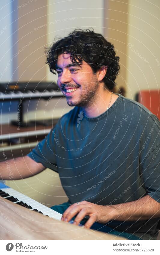 Smiling musician playing piano in a sound studio recording session male joyful professional talent passion instrument keyboard artist performer entertainment